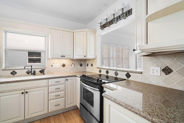 2772 NE 30th Ave Unit 8C, Lighthouse Point, FL 33064 - kitchen featuring stainless steel range with electric stovetop, a sink, light wood-type flooring, decorative backsplash, and light stone countertops