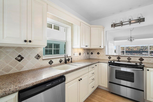 2772 NE 30th Ave Unit 8C, Lighthouse Point, FL 33064 - kitchen featuring stainless steel appliances, a sink, decorative backsplash, and light wood-style floors