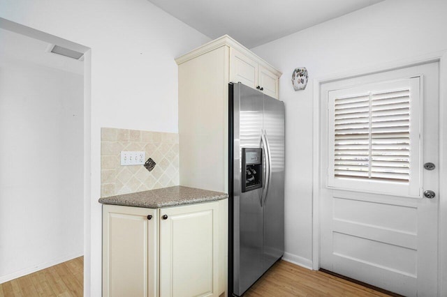 kitchen with stainless steel refrigerator with ice dispenser, tasteful backsplash, and light hardwood / wood-style flooring