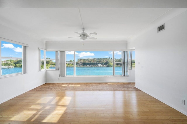 interior space with ceiling fan and a water view