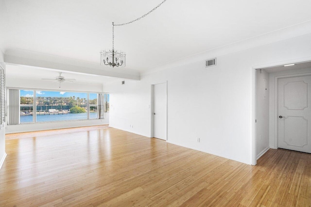 unfurnished living room with ceiling fan with notable chandelier and light hardwood / wood-style floors