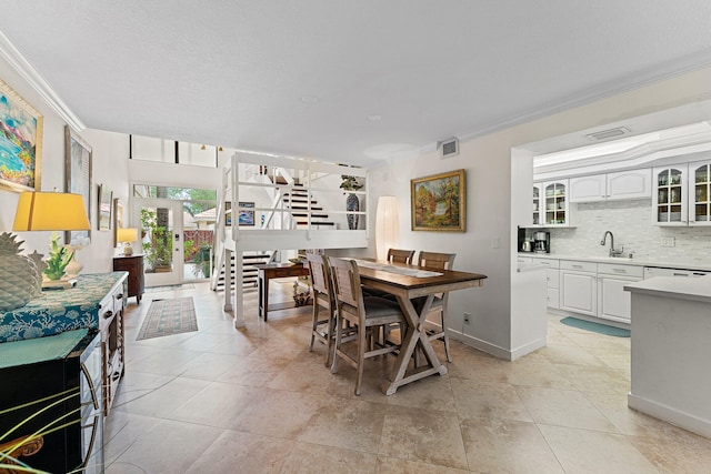 dining room featuring light tile patterned flooring, ornamental molding, and sink