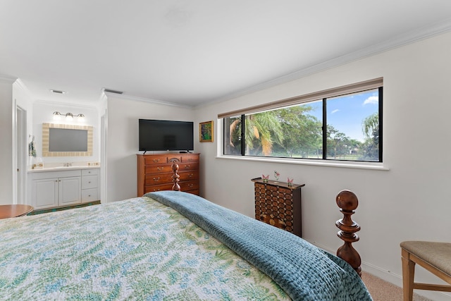 carpeted bedroom with ornamental molding, sink, and ensuite bath