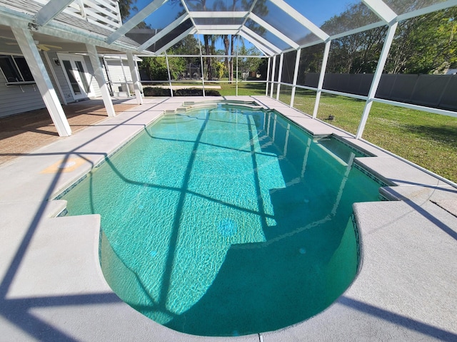 view of pool featuring a lawn, glass enclosure, french doors, and a patio