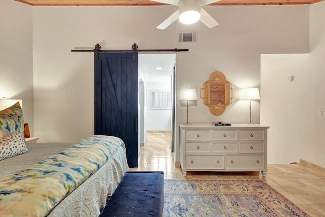 bedroom featuring ceiling fan and a barn door