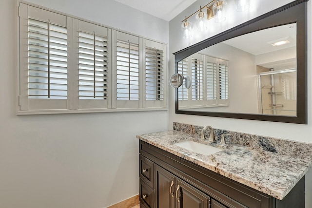 bathroom with vanity and a shower with door