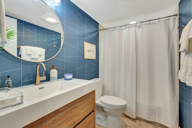 bathroom featuring a shower with shower curtain, tile patterned floors, vanity, tile walls, and toilet