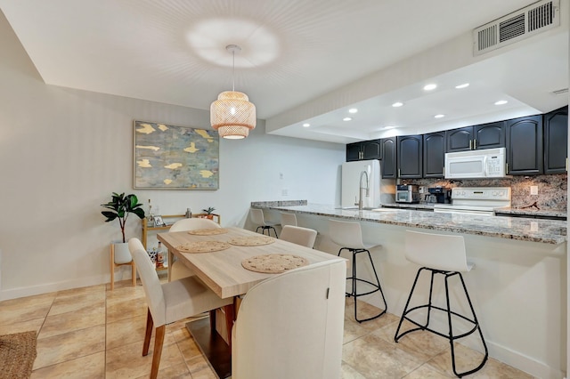 dining space with light tile patterned floors and sink