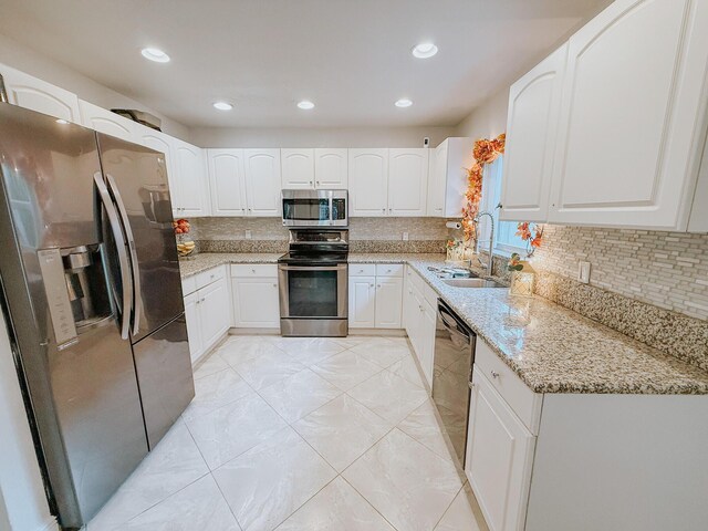 402 Shadow Wood Ln, Coral Springs, FL 33071 - kitchen with white cabinets, light stone countertops, stainless steel appliances, and tasteful backsplash