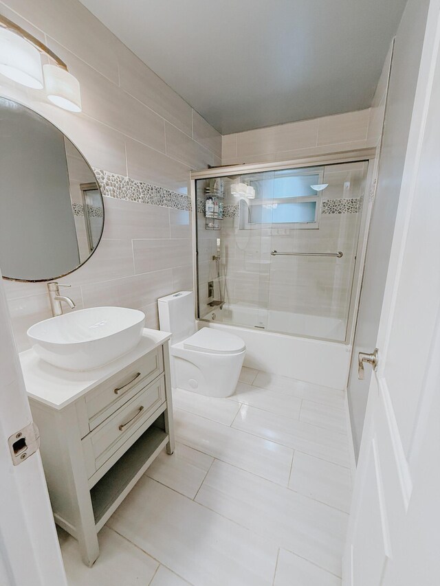 402 Shadow Wood Ln, Coral Springs, FL 33071 - full bathroom with combined bath / shower with glass door, vanity, tile walls, tile patterned flooring, and toilet