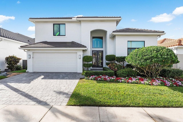 view of front facade with french doors, a front lawn, and a garage