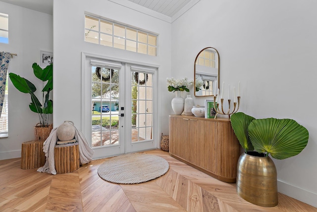 doorway featuring a towering ceiling, french doors, and light parquet flooring