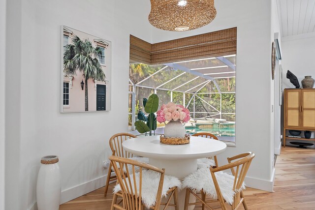 dining room with light hardwood / wood-style flooring, a notable chandelier, a healthy amount of sunlight, and wood ceiling