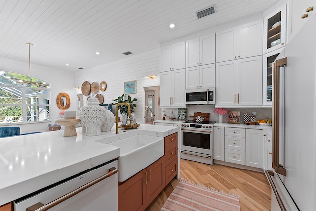 kitchen with white cabinets, hanging light fixtures, light hardwood / wood-style flooring, wood ceiling, and stainless steel appliances