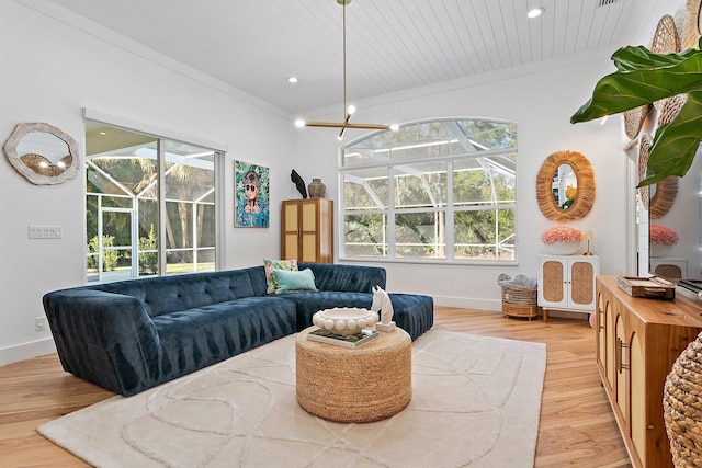 living room with a wealth of natural light, light hardwood / wood-style flooring, wood ceiling, and ornamental molding