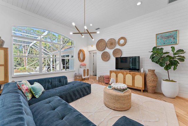 living room with wood ceiling, wooden walls, a chandelier, hardwood / wood-style floors, and lofted ceiling