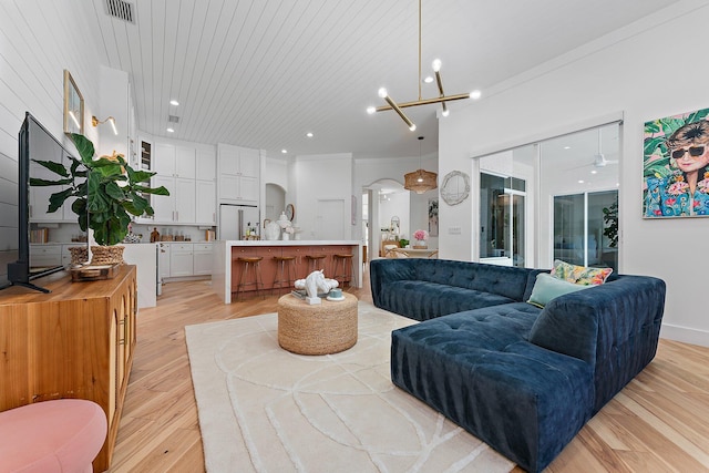 living room featuring a chandelier, light wood-type flooring, crown molding, and wood ceiling