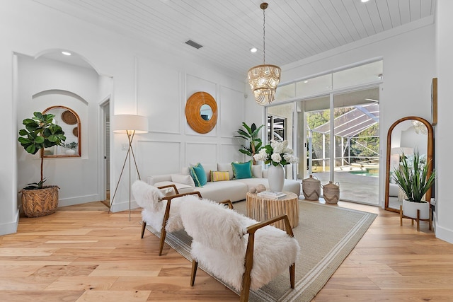 living room featuring light hardwood / wood-style floors, an inviting chandelier, and wooden ceiling