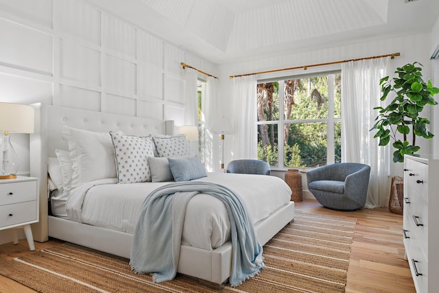 bedroom featuring a raised ceiling and light hardwood / wood-style floors