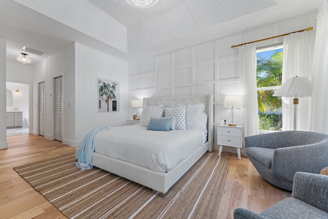 bedroom featuring connected bathroom and hardwood / wood-style flooring