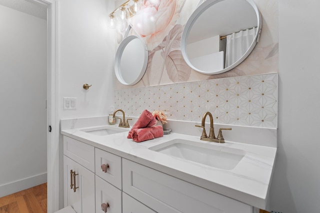 bathroom featuring vanity, hardwood / wood-style floors, and backsplash