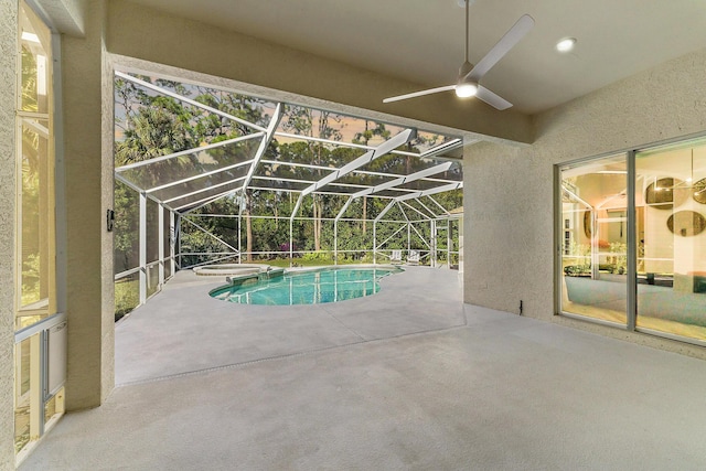 view of swimming pool featuring glass enclosure, a hot tub, ceiling fan, and a patio area