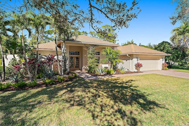 view of front of property featuring a garage, a front yard, and french doors