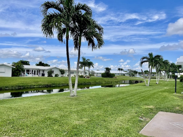 view of property's community with a yard and a water view