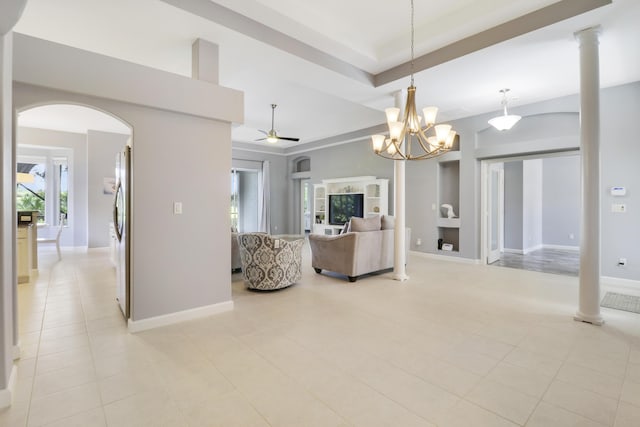 tiled living room featuring ceiling fan with notable chandelier, decorative columns, and built in shelves