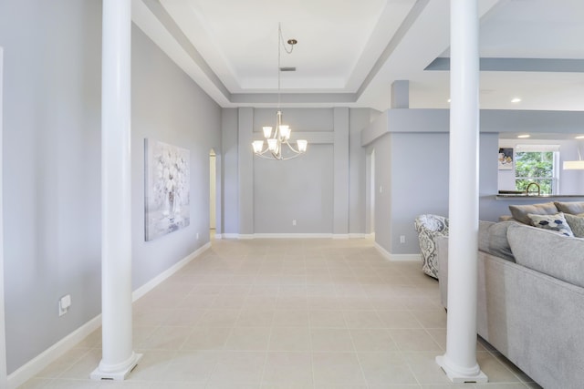 interior space with ornate columns, a raised ceiling, sink, light tile patterned floors, and an inviting chandelier