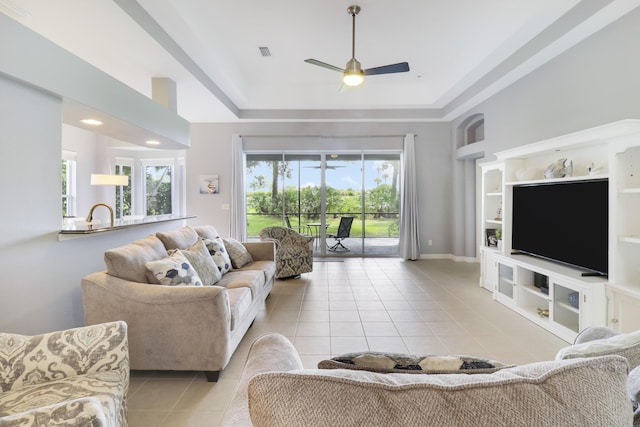 living room with built in shelves, ceiling fan, and light tile patterned floors