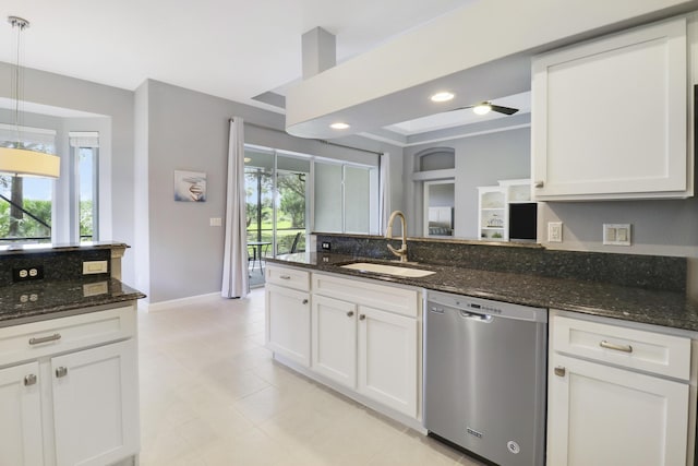 kitchen with dark stone countertops, dishwasher, white cabinets, and decorative light fixtures