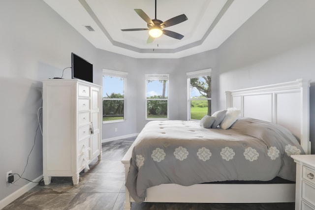 bedroom with a raised ceiling and ceiling fan