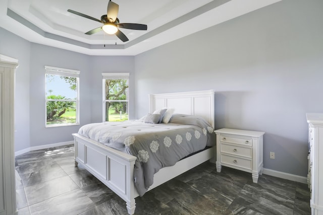 bedroom with a raised ceiling and ceiling fan