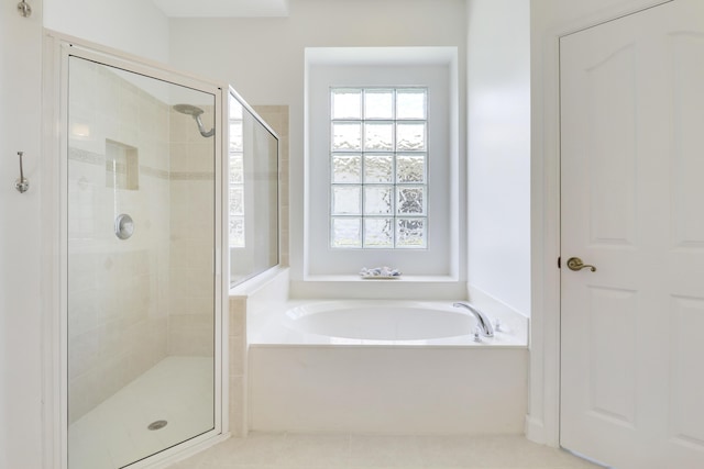 bathroom with tile patterned flooring and separate shower and tub