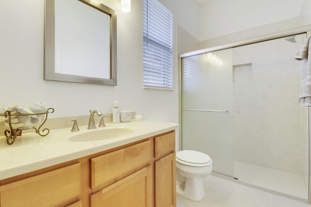 bathroom with tile patterned floors, vanity, a healthy amount of sunlight, toilet, and a shower with shower door