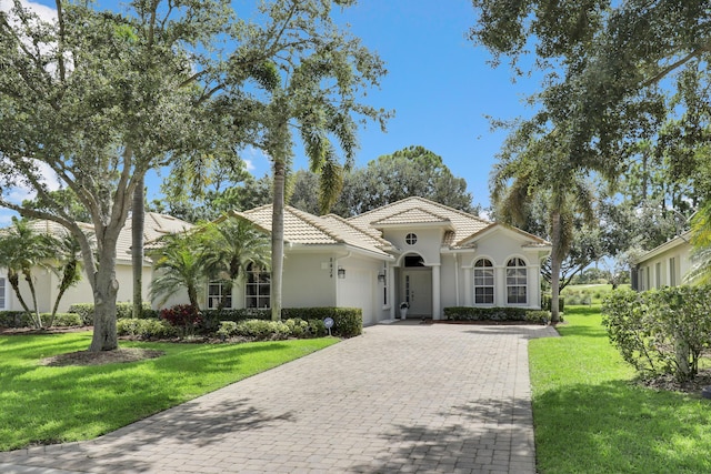 mediterranean / spanish home with a front lawn