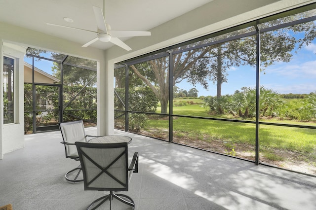 unfurnished sunroom featuring ceiling fan and a wealth of natural light