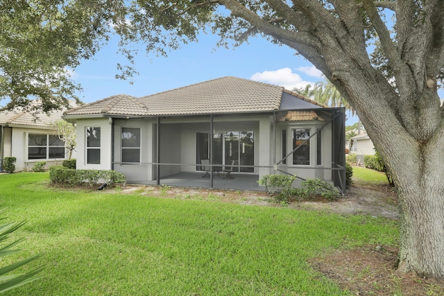 rear view of property featuring a yard and a patio area