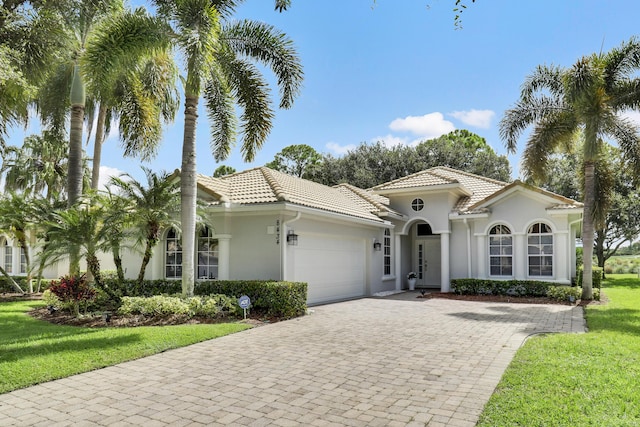 mediterranean / spanish-style house featuring a garage and a front yard