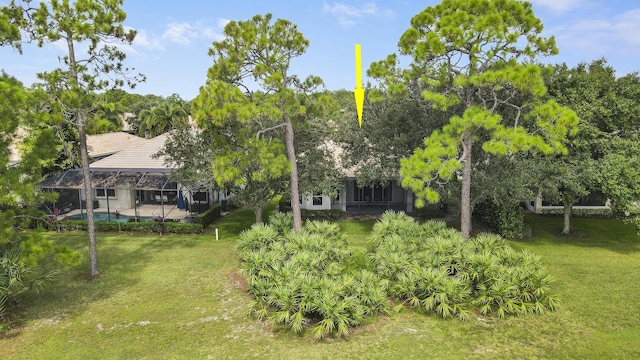 view of yard with glass enclosure and a swimming pool