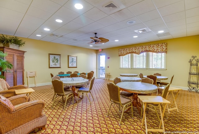 dining area with ceiling fan, a drop ceiling, and light colored carpet