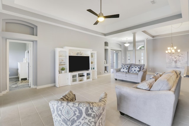 tiled living room featuring ceiling fan with notable chandelier and a raised ceiling