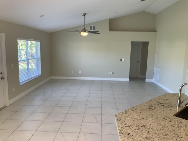 empty room featuring visible vents, vaulted ceiling, baseboards, and ceiling fan