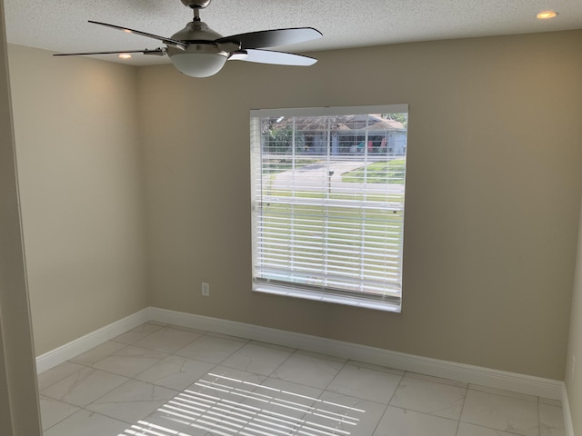 unfurnished room featuring ceiling fan and a textured ceiling