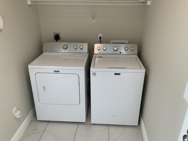 laundry room featuring marble finish floor, washing machine and clothes dryer, laundry area, and baseboards