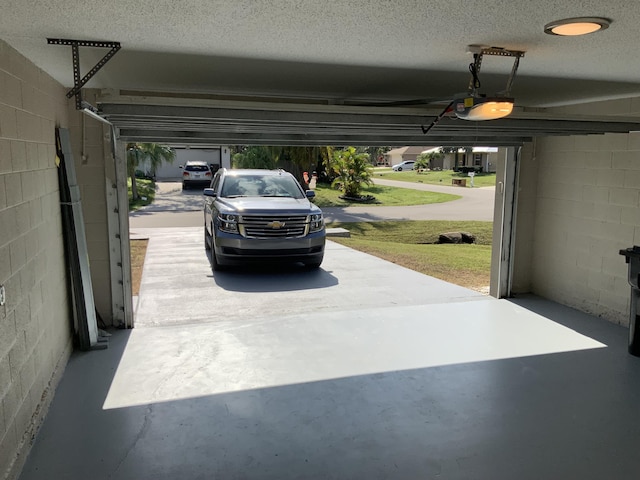 garage featuring a garage door opener and concrete block wall