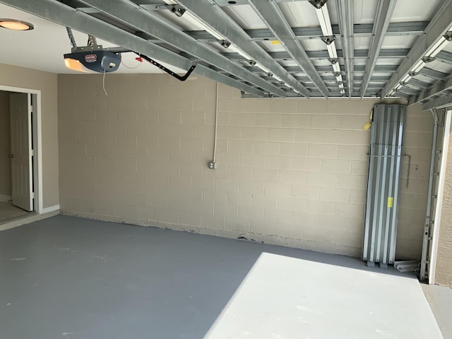 garage with concrete block wall and a garage door opener