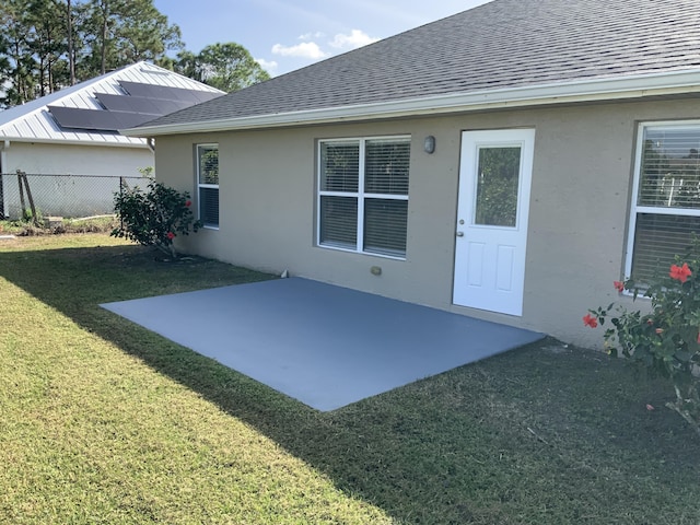 rear view of house featuring a lawn and a patio