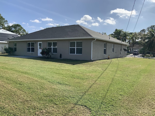 back of property with a patio, a lawn, fence, and stucco siding